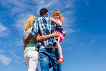 Familie, sich umarmend, Rücken zur Kamera leichte Untersicht
