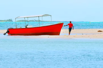 Crédence de cuisine en verre imprimé Sports nautique Bateau à moteur rouge sur l& 39 océan Indien près de l& 39 île aux Cerfs (île Maurice). Mer bleue et plage au paradis tropical.