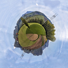 Miniature planet of valley with agriculture fields between mountains