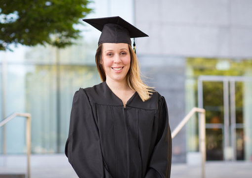 Portrait of female college student in graduation cap and gown on