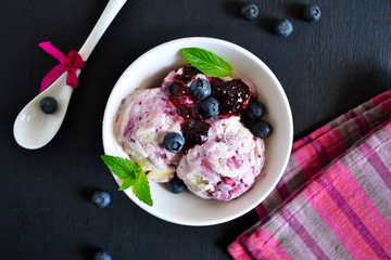 Vanilla ice cream with blueberries on the black background, top