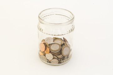 Transparent bank with coins of different metals of different denominations from different countries