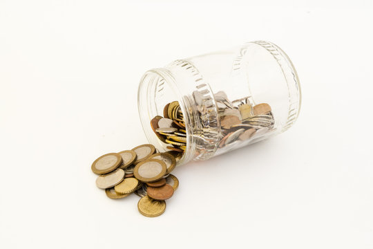 Transparent bank with coins of different metals of different denominations from different countries