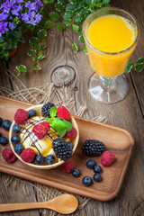 Tasty ice cream dessert with fruit in a waffle bowl.