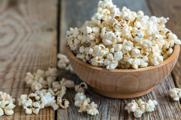 Popcorn in wooden bowl close up.