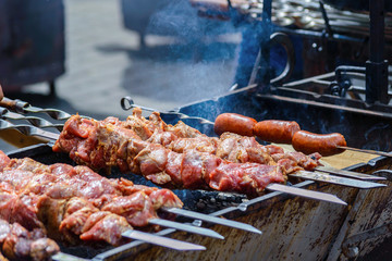cooking meat and sausages on skewers