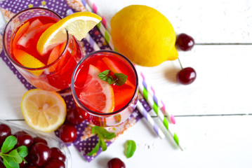 Summer cold drink - lemonade with a cherry on a white background