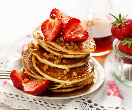 Pancakes with fresh strawberries, maple syrup and caramel topping