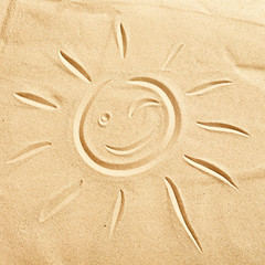 Fototapeta na wymiar Smiling winking happy sun on golden beach sand