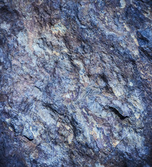 Stone background, rock wall backdrop with rough texture. Abstract, grungy and textured surface of stone material. Nature detail of rocks.