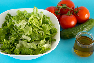 Fresh tomato, lettuce and cucumber for salad with olive oil