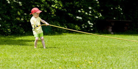 Child drags hose with water
