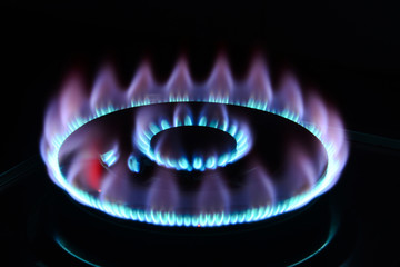 The blue flame of a cooker burner in the dark