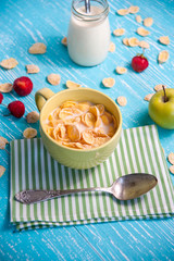 cornflakes with strawberry, apple and jar milk on wooden table