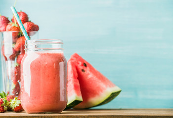 Freshly blended red fruit smoothie in glass jar with straw