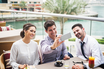 Business people making selfie at cafe bar.