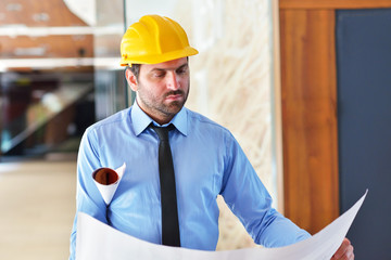 Portrait of a happy young architect standing in his office