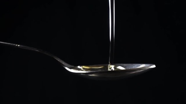 Super slow motion close video (500 fps) of sunflower oil being poured in spoon
