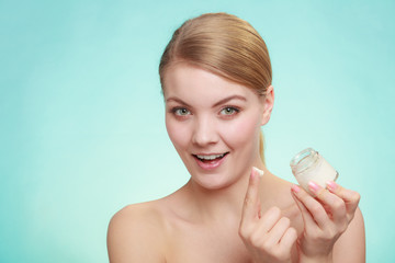 woman applying cream on her skin face.