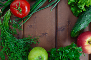 Photo of a table top full of fresh vegetables, fruit, and other healthy foods with a space in the middle for text.