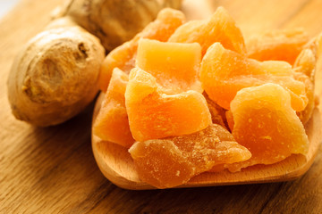 Closeup root and candied ginger on wooden table