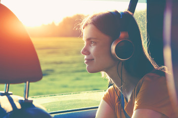 smiling pretty girl listening to music with headphones moving in