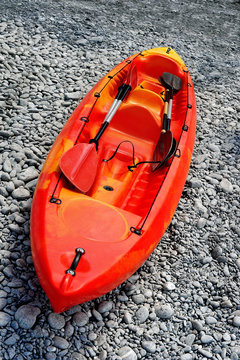 red kayak with oarson on sea beach