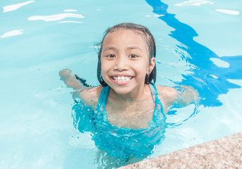 Fototapeta na wymiar Little asian kids girl in swimming pool. Summer outdoor.