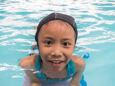 Little asian kids girl in swimming pool. Summer outdoor.