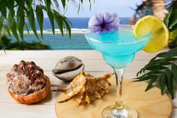 Blue Hawaiian cocktail on the tropical sea background