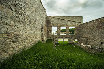 Fototapeta na wymiar Ruins Of Fayette Ghost Town. Interior of an abandoned building with open windows facing the limestone cliffs on Lake Michigan. Fayette State Historical Park.