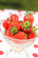 Fresh strawberries in a glass cup, close up in the garden