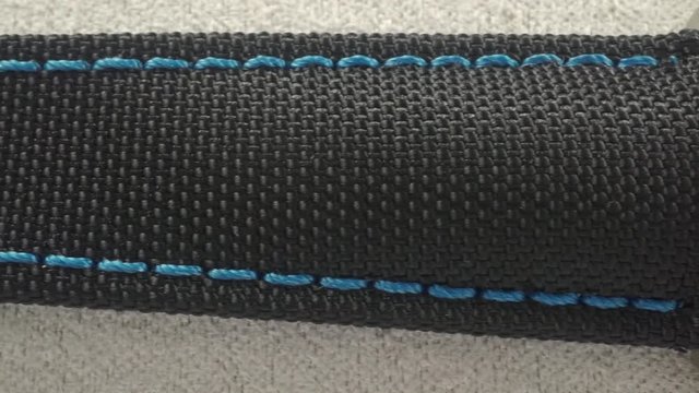 Black watch bracelet with blue stitches, macro dolly shot