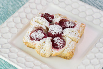 Fresh baked berries cream cheese pastry on a white plate..