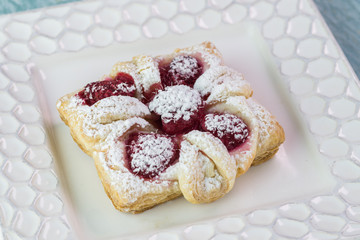 Fresh baked berries cream cheese pastry on a white plate..