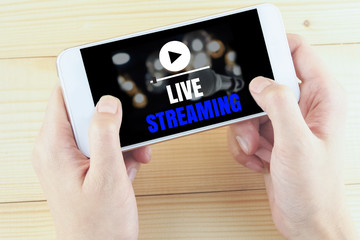 word live streaming on smartphone in hand on wooden desk