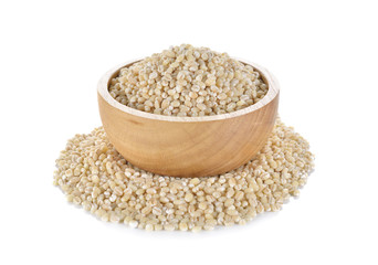 Uncooked barley grain seeds in wooden bowl and on white backgrou