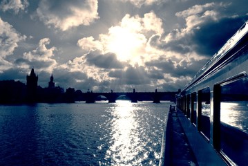 Boat cruise on the Vltava river in Prague, on a sunny day, in black and white. Monochrome cityscape filtered in vintage styla with soft focus and red filter; high contrast dramatic effect. - 113583115