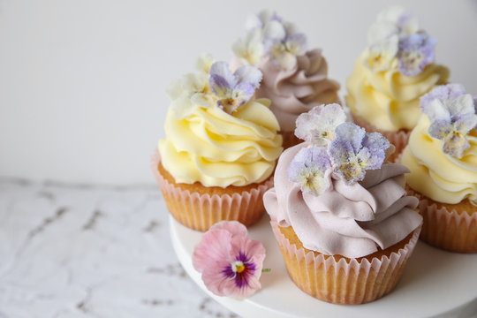 Purple And Yellow Almond Coconut Cupcakes With Sugared Edible Flowers On Cake Stand, Keto Dessert