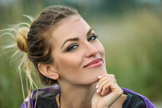 Fototapeta Outdoor portrait of beautiful smiling woman with bright  professional make-up.