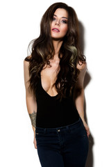 Glamour portrait of beautiful girl model with makeup and romantic wavy hairstyle. Fashion shiny highlighter on skin, sexy gloss lips make-up and dark eyebrows.