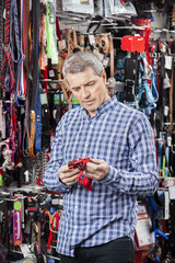 Customer Examining Belt At Pet Store