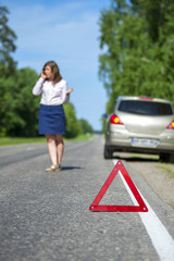Woman calling to a car assistance after breakdown