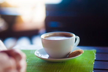 cup of hot coffee on table with cookie