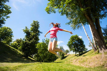 Woman in park, jumping.