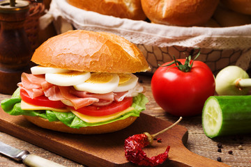 Prosciutto ham sandwich with egg and vegetables.
