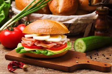 Prosciutto ham sandwich with egg and vegetables.