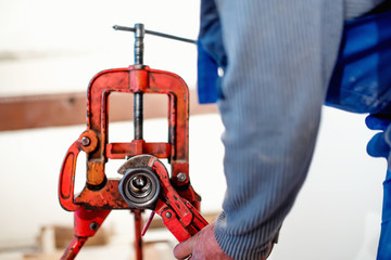 handyman using wrench at industrial plumbing