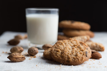 Cookies pile with chocolate chip and almond on light textile background. Delicious morning snacks for breakfast, brunch and lunch. Appetizing, healthy and fast food