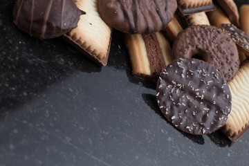 Cookies assorted on black background. Delicious morning snacks for breakfast, brunch and lunch. Appetizing, sweet and fast food.